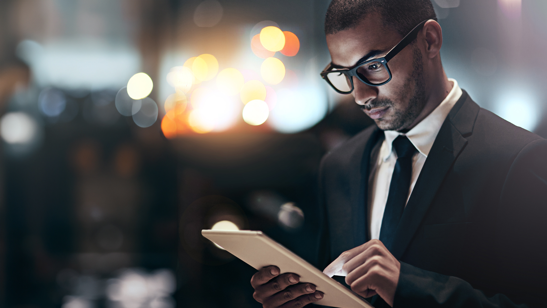 Well-dressed businessman using a digital tablet device to read that Microsoft confirms extended security updates for SQL Server 2014