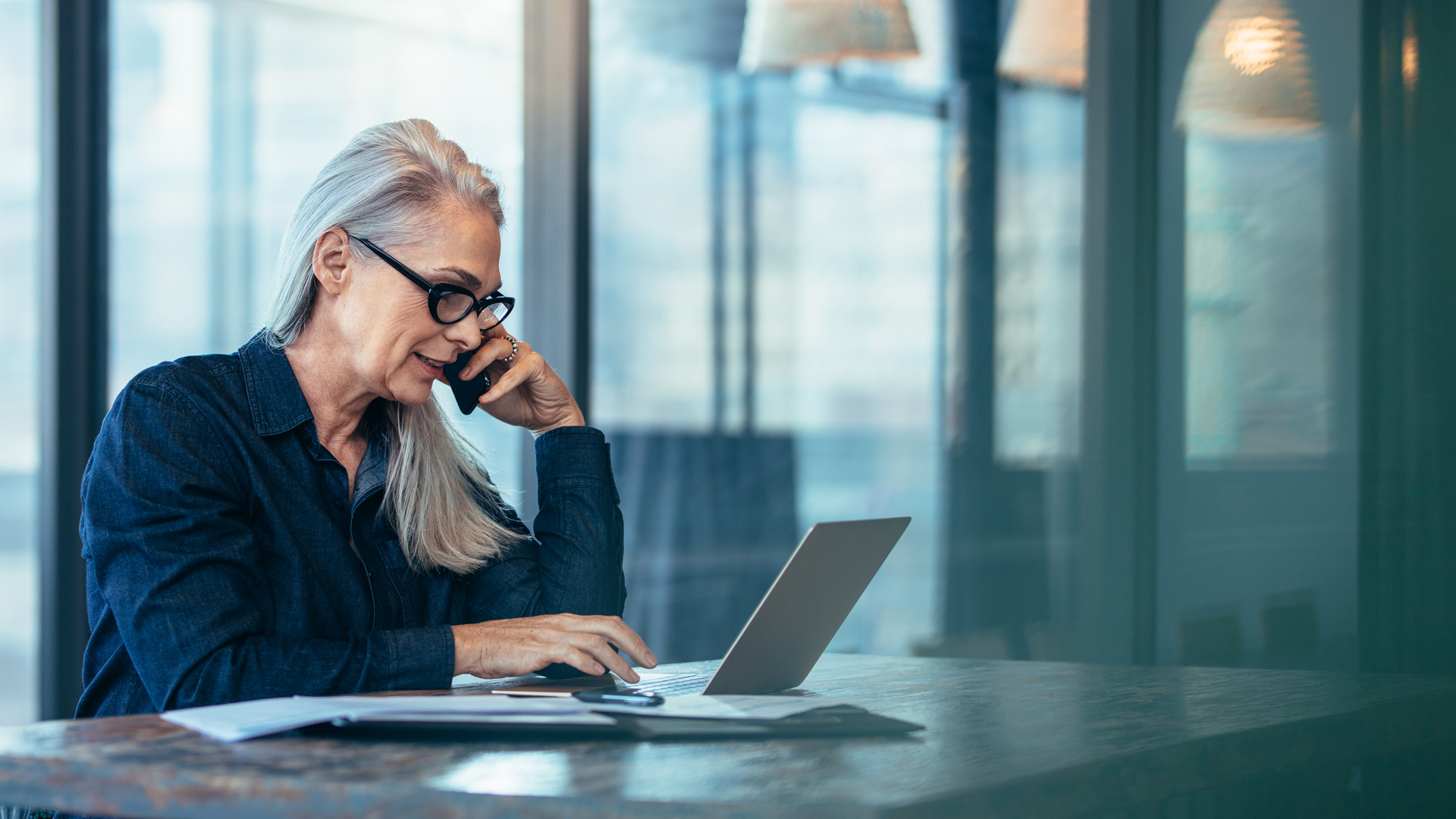 Senior executive seated in a modern office workspace while speaking on a mobile device about how to recover Your Microsoft Copilot AI investment