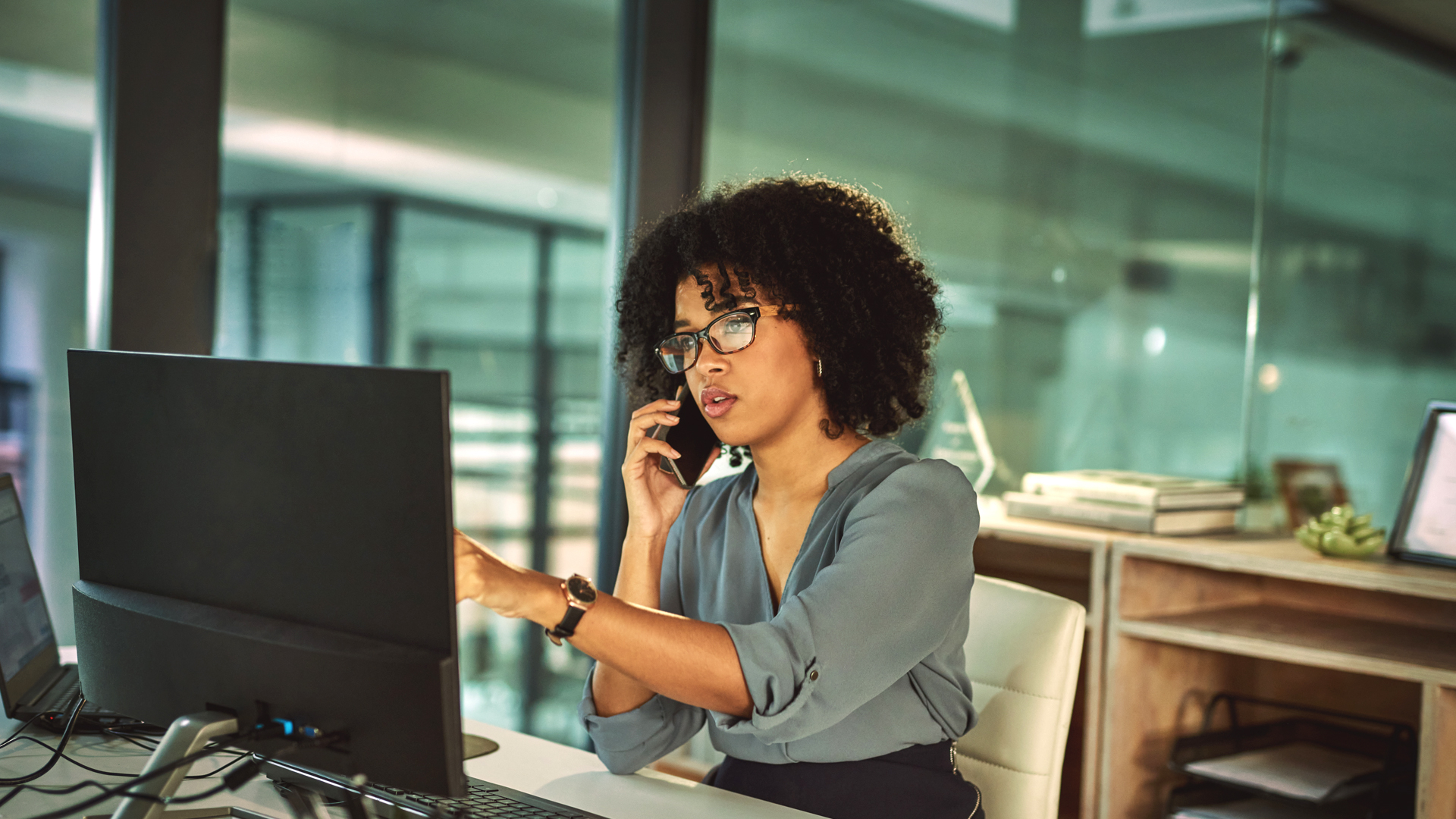 Young professional in a modern office environment speaking with service provider the role that Managed IT Services can play in her business