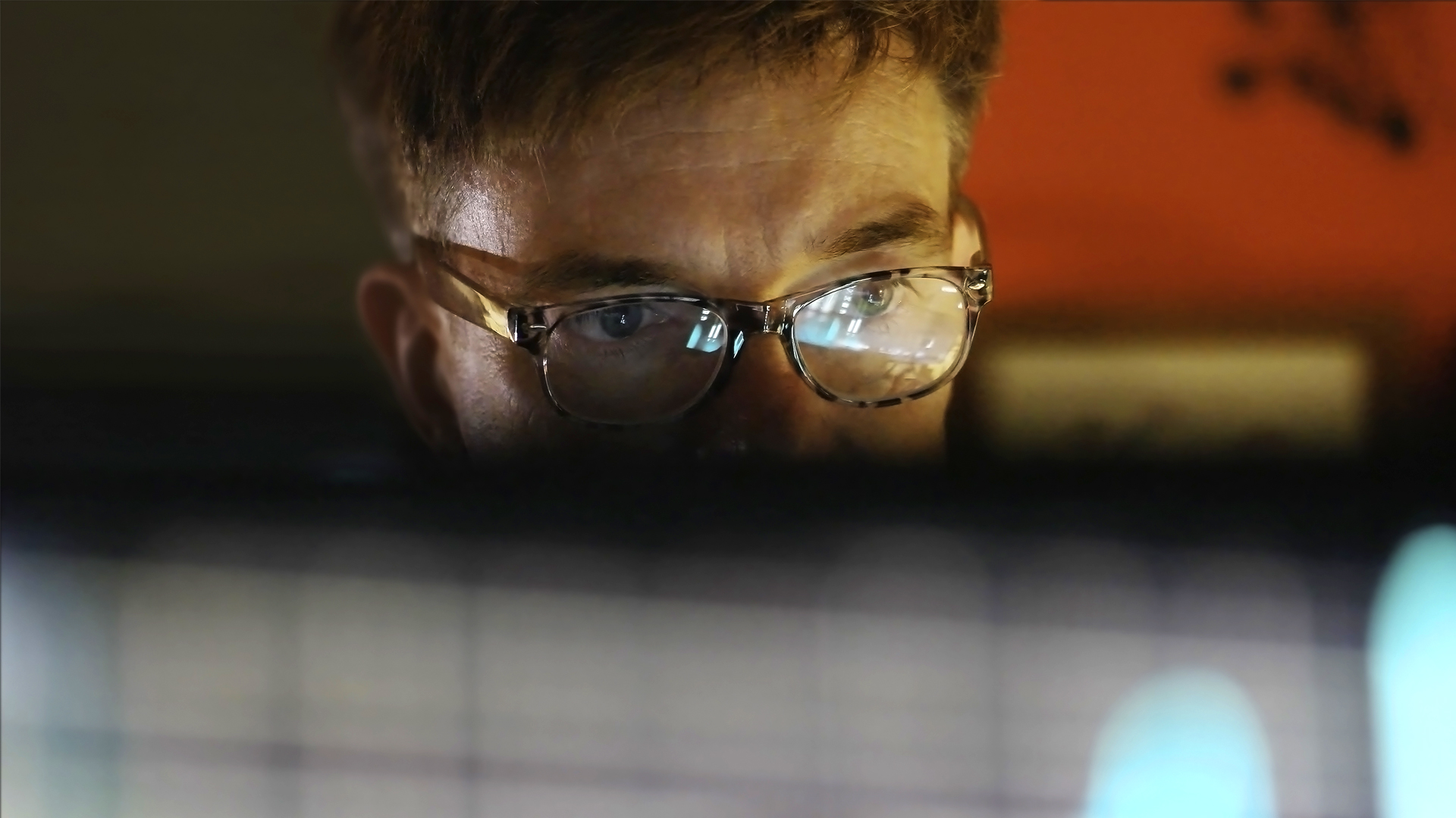Technology professional viewing a desktop monitor whilst considering the Advancement of Infrastructure Management with Azure Bicep