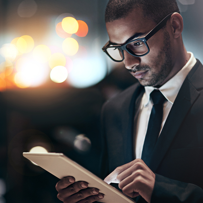 Well-dressed businessman using a digital tablet device to read that Microsoft confirms extended security updates for SQL Server 2014